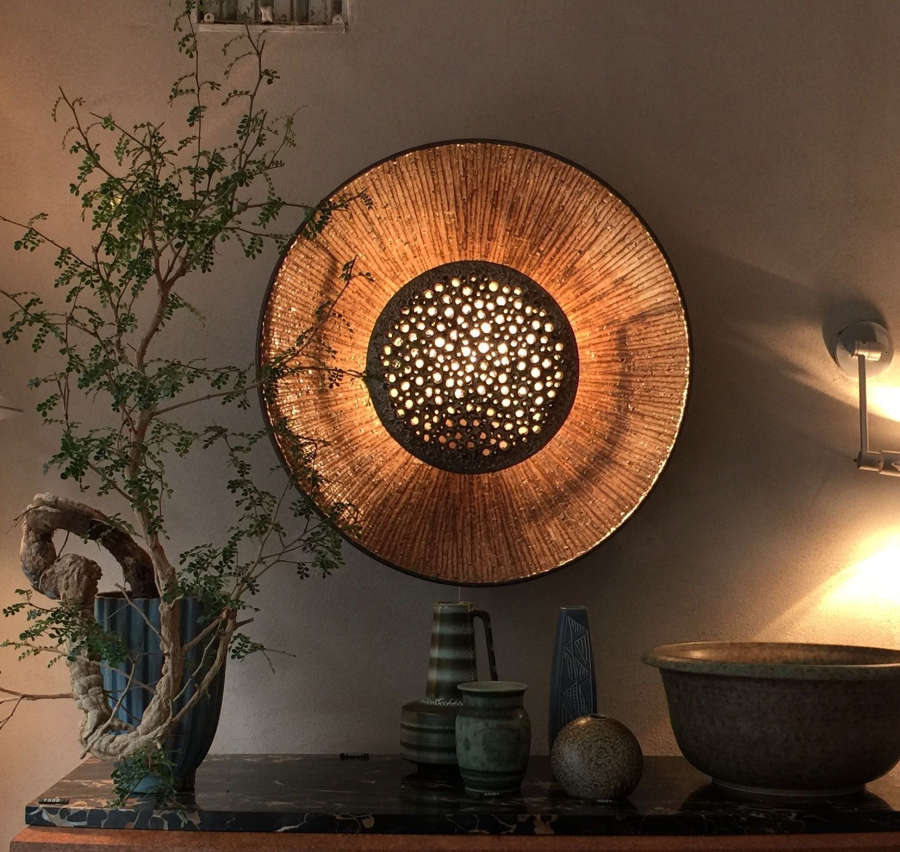 Ceramic wall sconce that resembles a sunflower.