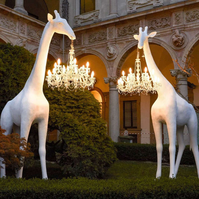 Floor lamp in shape of full size giraffe with a crystal chandelier hanging from its mouth