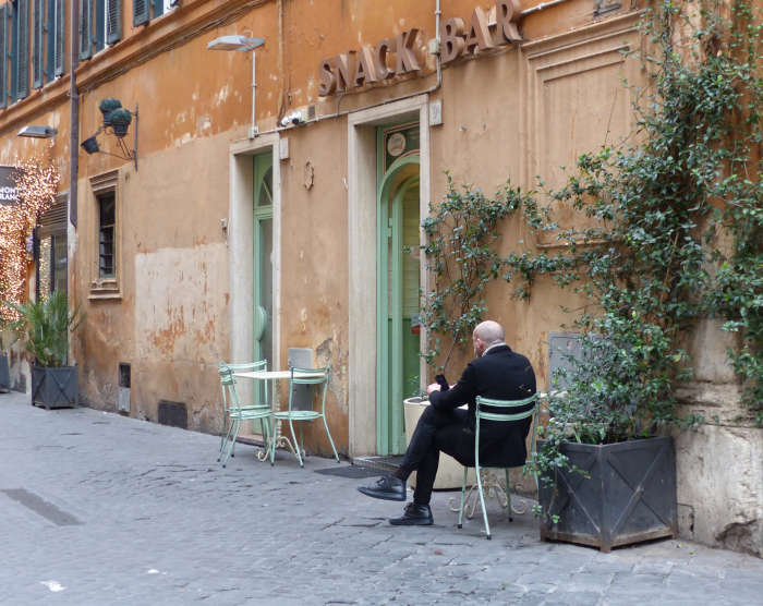 Lone customer on a cobbled street's sidewalk table 