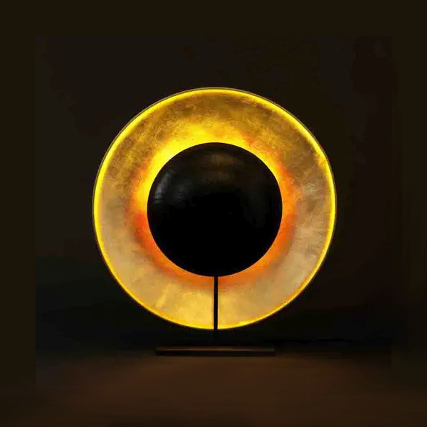 Table lamp of copper gilded rice paper form with a a smaller black painted rice paper form in front, creating the look of a solar eclipse.