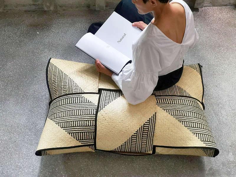 A pouf made with plaited rattan.