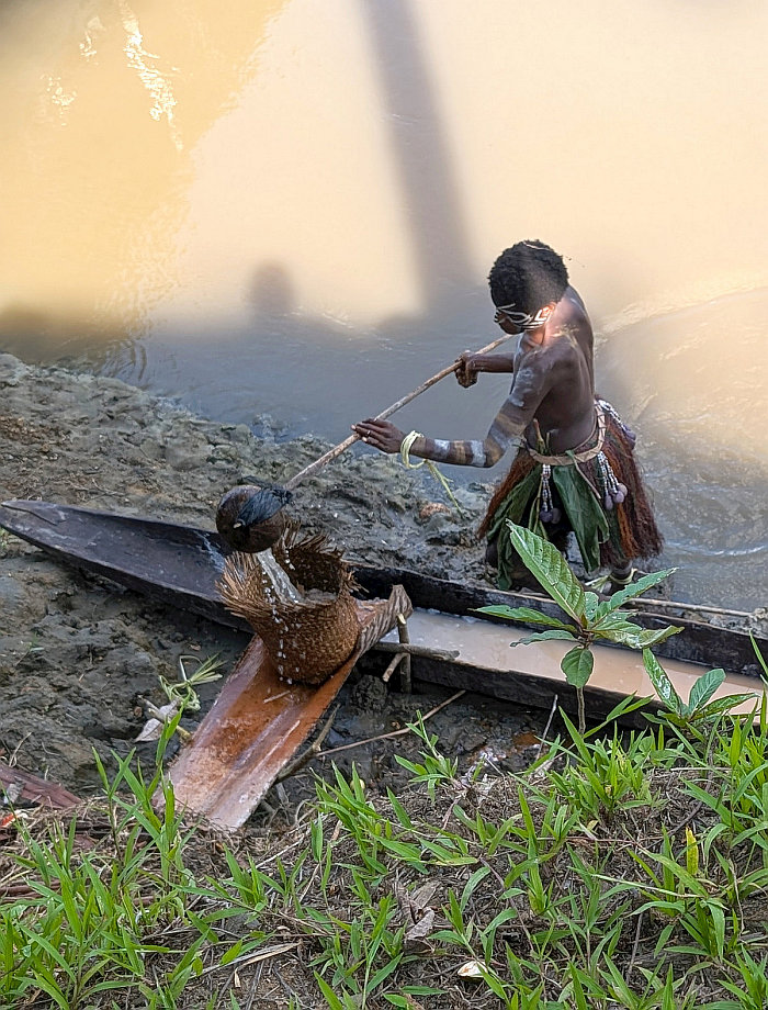 Karawari Village woman rinsing and straining sago pulp for residual starch